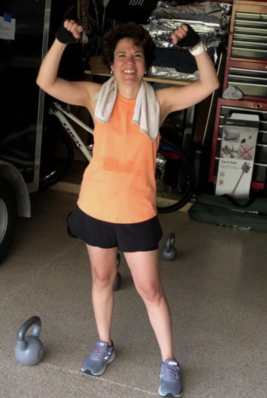 Client flexing mid-workout with kettlebells